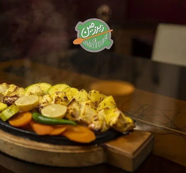 سینی داغ جوجه کباب و سبزیجات گریل‌شده با لیمو در کافه رستوران زیرزمین، غذایی لذیذ و تازه برای مشتریان.