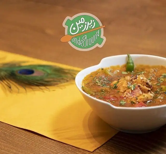 کافه رستوران زیرزمین: کاسه غذای لذیذ با ادویه، فلفل و گشنیز، دکوراسیون گرم با پر طاووس و رانر زرد. سفارش آنلاین غذای خوشمزه.