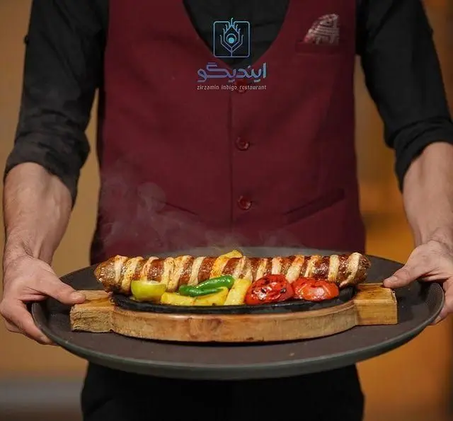 پیشخدمت کافه رستوران زیرزمین در حال سرو کباب داغ با گوجه و فلفل گریل شده روی سینی چدنی، تجربه غذایی لذت بخش و خاطره انگیز