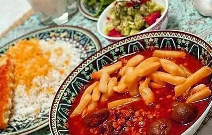 سفره‌ای رنگین از غذای سنتی ایرانی: خورشت قیمه با سیب زمینی، چلو زعفرانی و سالاد در رستوران سنتی دیزی میزی.