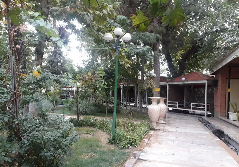 فضای دلنشین و سرسبز رستوران باغ گلستان با آلاچیق‌های زیبا و مسیر سنگی، مکانی عالی برای صرف غذا در طبیعت.