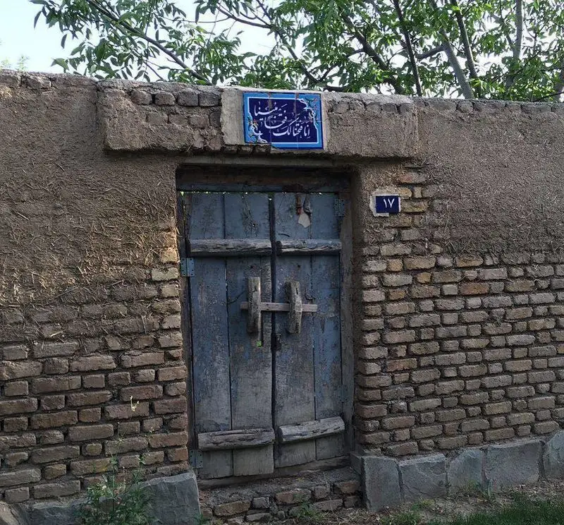 ورودی جذاب و سنتی رستوران باغ گلستان با درب چوبی قدیمی و دیوار آجری و کاهگلی، دعوت به تجربه‌ای دلنشین در فضایی آرام.