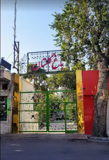 نمای بیرونی و ورودی زیبای رستوران باغ گلستان با درب بزرگ سبز و فضای سبز دلنشین، نشانگر محیطی آرام برای مشتریان.