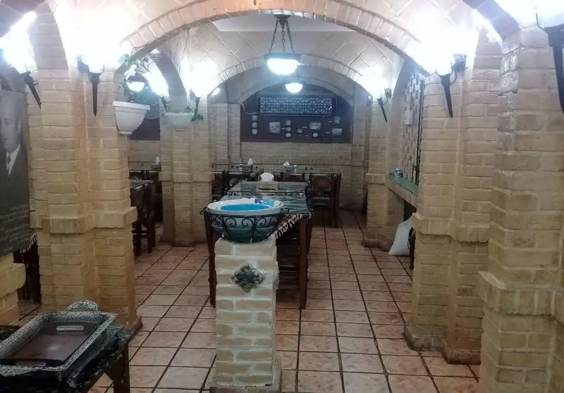 تصویری از فضای داخلی رستوران سنتی خان باجی با دیوارهای آجری، سقف طاقدار و چیدمان میز و صندلی‌ها، مکانی دنج برای لذت از غذای باکیفیت.