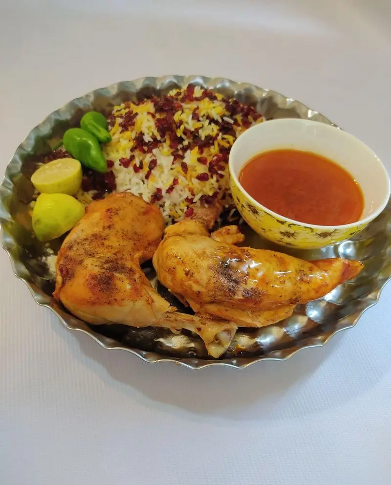 زرشک پلو با مرغ بریان و سس مخصوص، یک غذای سنتی و لذیذ ایرانی ارائه شده توسط کترینگ لوتوس، مناسب برای مهمانی ها.