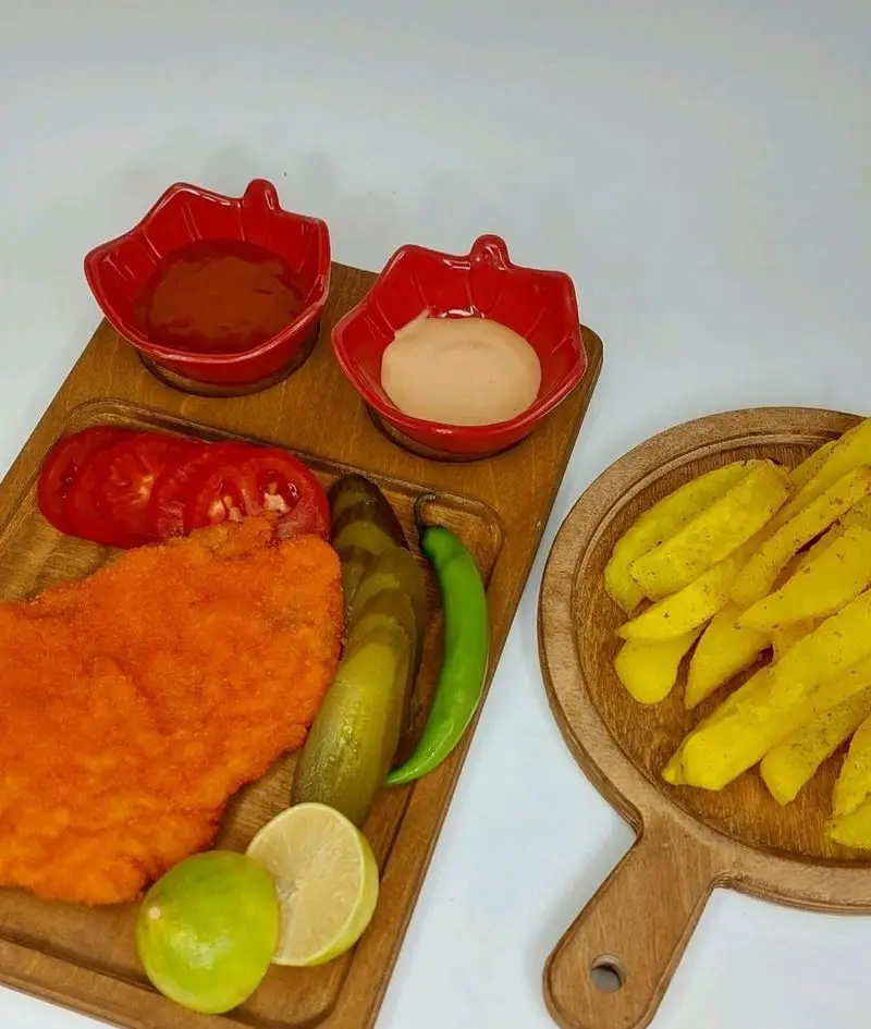 خوراک شنیتسل مرغ پرسی کترینگ لوتوس با سیب زمینی سرخ کرده، خیارشور و سس. سفارش آنلاین غذای آماده و فست فود خوشمزه.