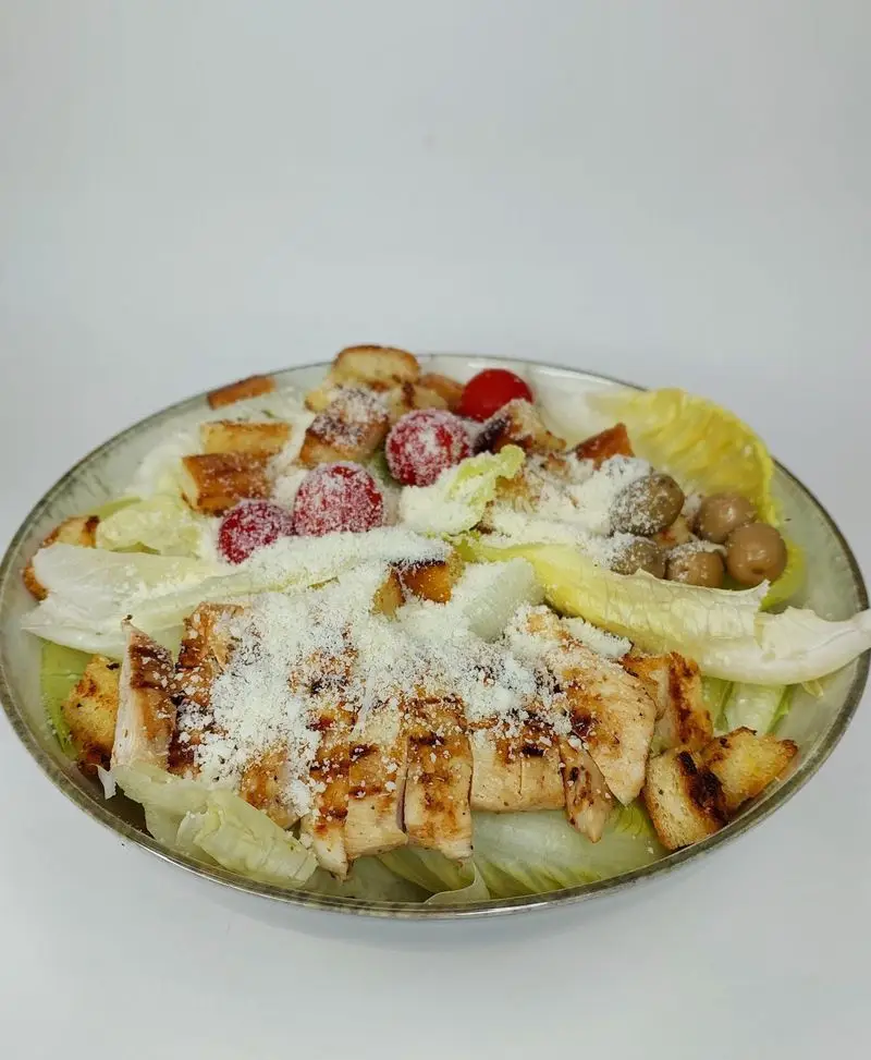 سالاد سزار کترینگ لوتوس با مرغ گریل شده، کروتون ترد و پنیر پارمزان. غذایی سالم، خوشمزه و آماده برای سفارش از لوتوس.