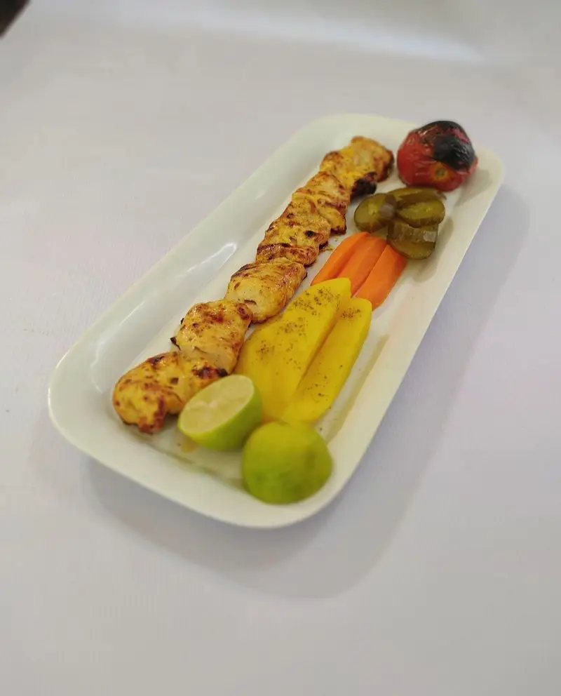 جوجه کباب لوتوس با دورچین گوجه کبابی، ترشی، هویج، سیب زمینی و لیمو. غذای اصیل ایرانی و خانگی از کترینگ لوتوس.