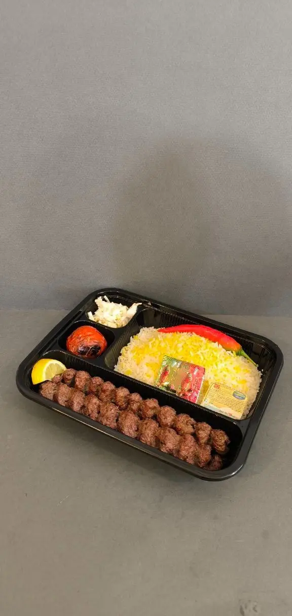 غذای بیرون بر کترینگ لوتوس شامل کباب کوبیده، برنج زعفرانی، گوجه کبابی، لیمو و سالاد در بسته‌بندی تک نفره شیک و باکیفیت.