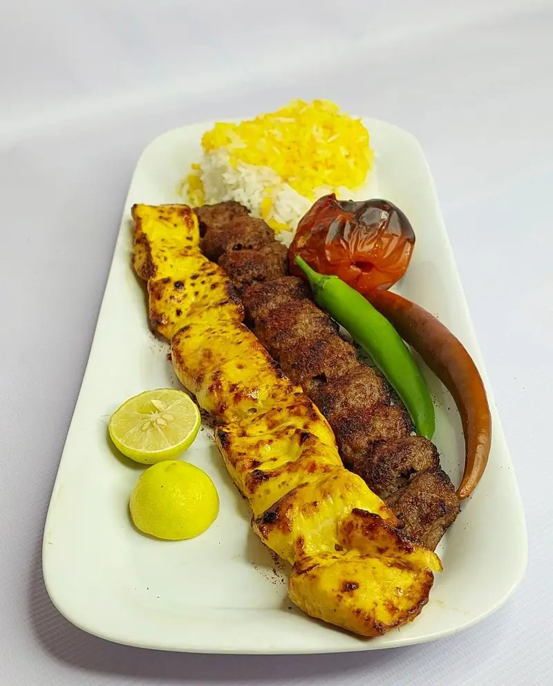 چلو کباب کوبیده و جوجه کباب ممتاز لوتوس، برنج زعفرانی، گوجه کبابی و فلفل. بهترین غذای ایرانی کترینگ لوتوس