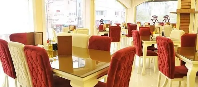 نمایی از فضای داخلی رستوران پیتزایی ایران ویچ، با طراحی مدرن و شیک شامل میز و صندلی‌های راحت قرمز و سفید برای مشتریان