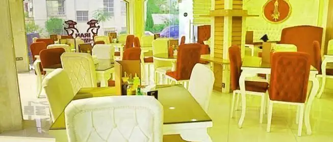 نمای داخلی پیتزایی ایران ویچ با چیدمان میز و صندلی‌های شیک و مدرن، فضایی دنج و روشن برای تجربه غذایی لذت‌بخش.