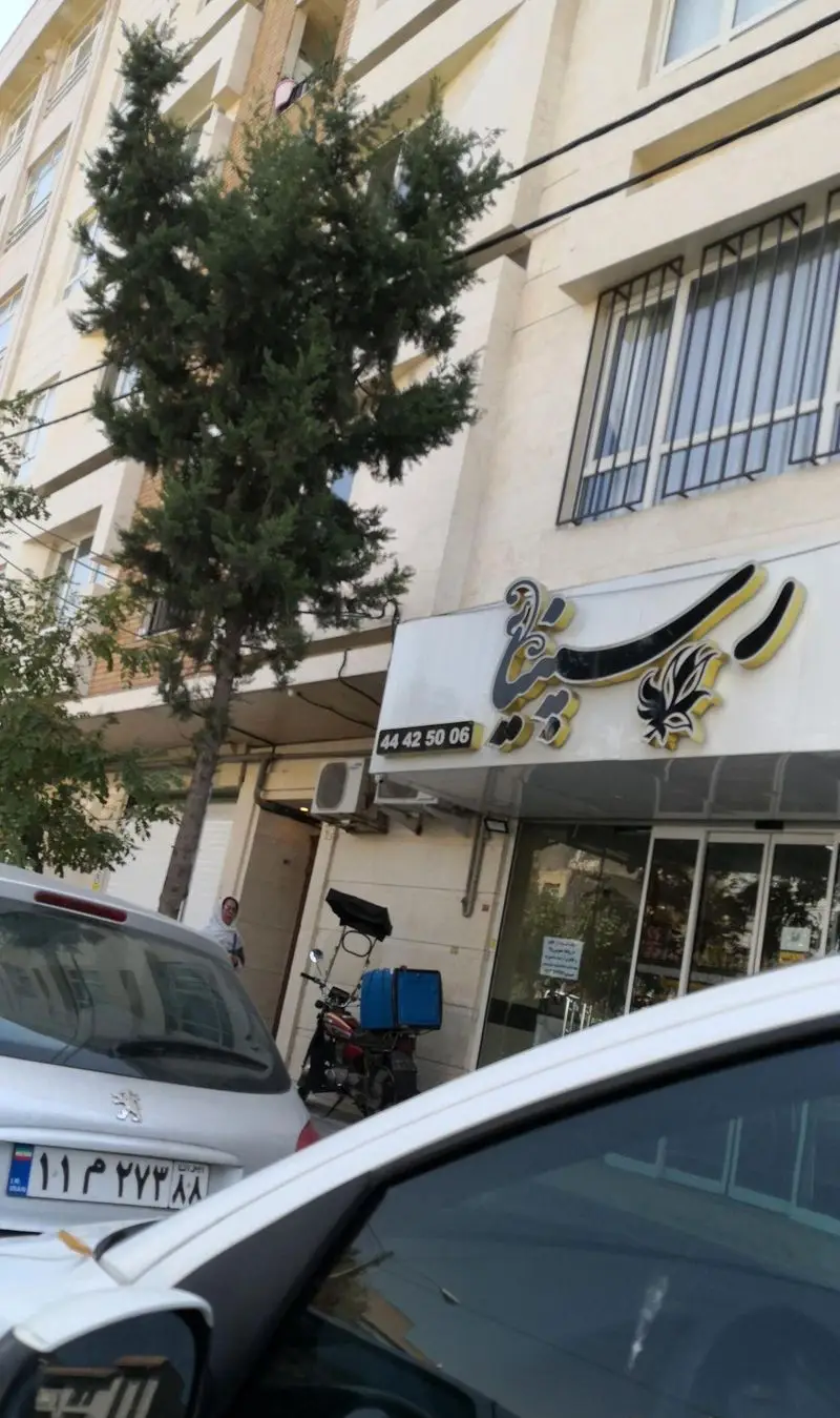 تصویر فست فود پیتزا رسپینا در شهر، تابلوی با نام رستوران و شماره تماس 44425006، موتور سیکلت دلیوری آماده ارسال سفارشات.