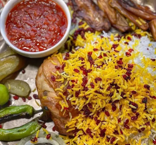 زرشک پلو با مرغ زعفرانی و خوشمزه رستوران گیلار، با سس مخصوص، بادمجان کبابی، خیارشور و فلفل کبابی. غذای اصیل ایرانی.