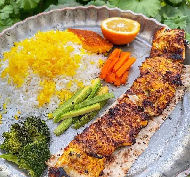 جوجه کباب ویژه رستوران گیلار با چلو زعفرانی، کدو، هویج و بروکلی تازه، یک ترکیب کامل و خوشمزه از غذای ایرانی.