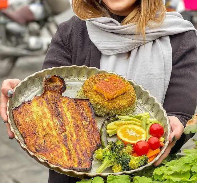 غذای سنتی و خوشمزه رستوران گیلار: ماهی طلایی با سبزی پلو، کدو حلوایی، بروکلی، گوجه فرنگی و پرتقال. سالم و لذیذ.