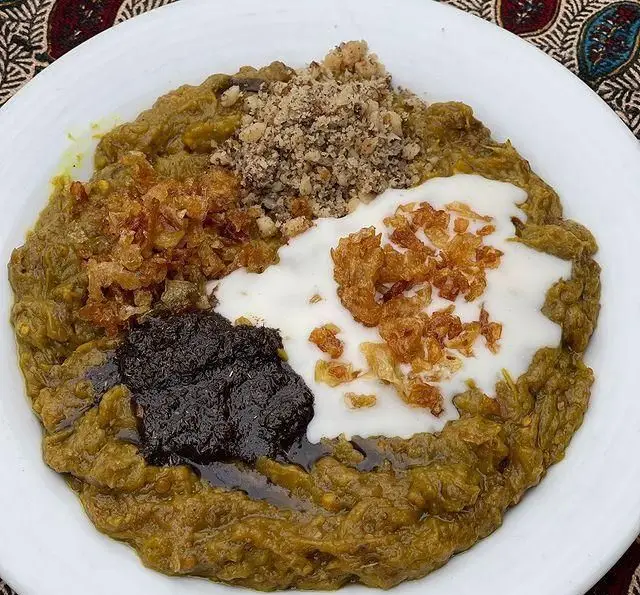 کشک بادمجان لذیذ رستوران گیلار با تزیین کشک، پیاز داغ، نعناع داغ و گردو، غذای اصیل و سنتی ایرانی و گیلانی