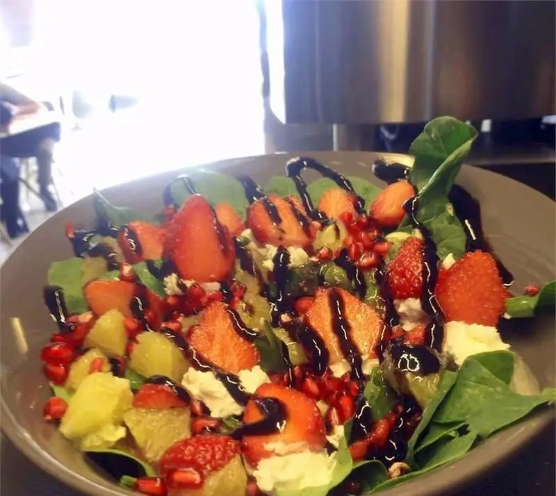 سالاد میوه تازه و رژیمی کافه رستوران ویراک با اسفناج، توت فرنگی، آناناس، انار، پنیر و سس بالزامیک.