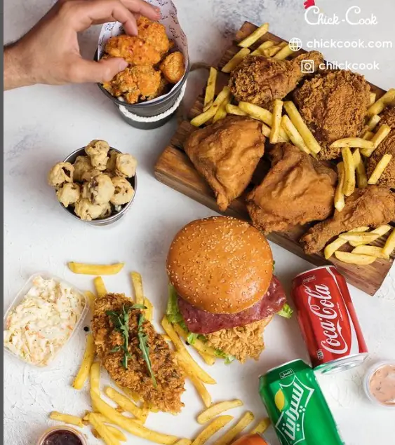 سفره ای پر از غذاهای خوشمزه چیک کوک: مرغ سوخاری، برگر مرغ کنتاکی، فیله کریسپی، قارچ سوخاری، ناگت و سیب زمینی سرخ کرده با نوشابه.