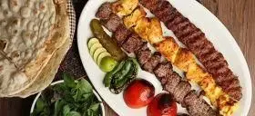 مجموعه کباب های ایرانی شامل کوبیده، جوجه و چنجه به همراه نان داغ، سبزیجات تازه، گوجه و فلفل کبابی از رستوران و کبابی گلپایگانی.