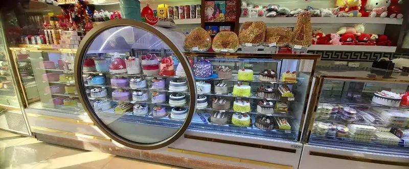 ویترین خیره‌کننده نان شیرینی کندو، مملو از انواع کیک‌های تازه و شیرینی‌های رنگارنگ برای جشن‌ها و مناسبت‌های خاص. بهترین قنادی.