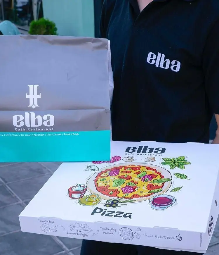 نمایی از بسته بندی پیتزا و غذای کافه رستوران البا در دست پیک دلیوری، آماده برای ارسال به مشتریان گرامی.