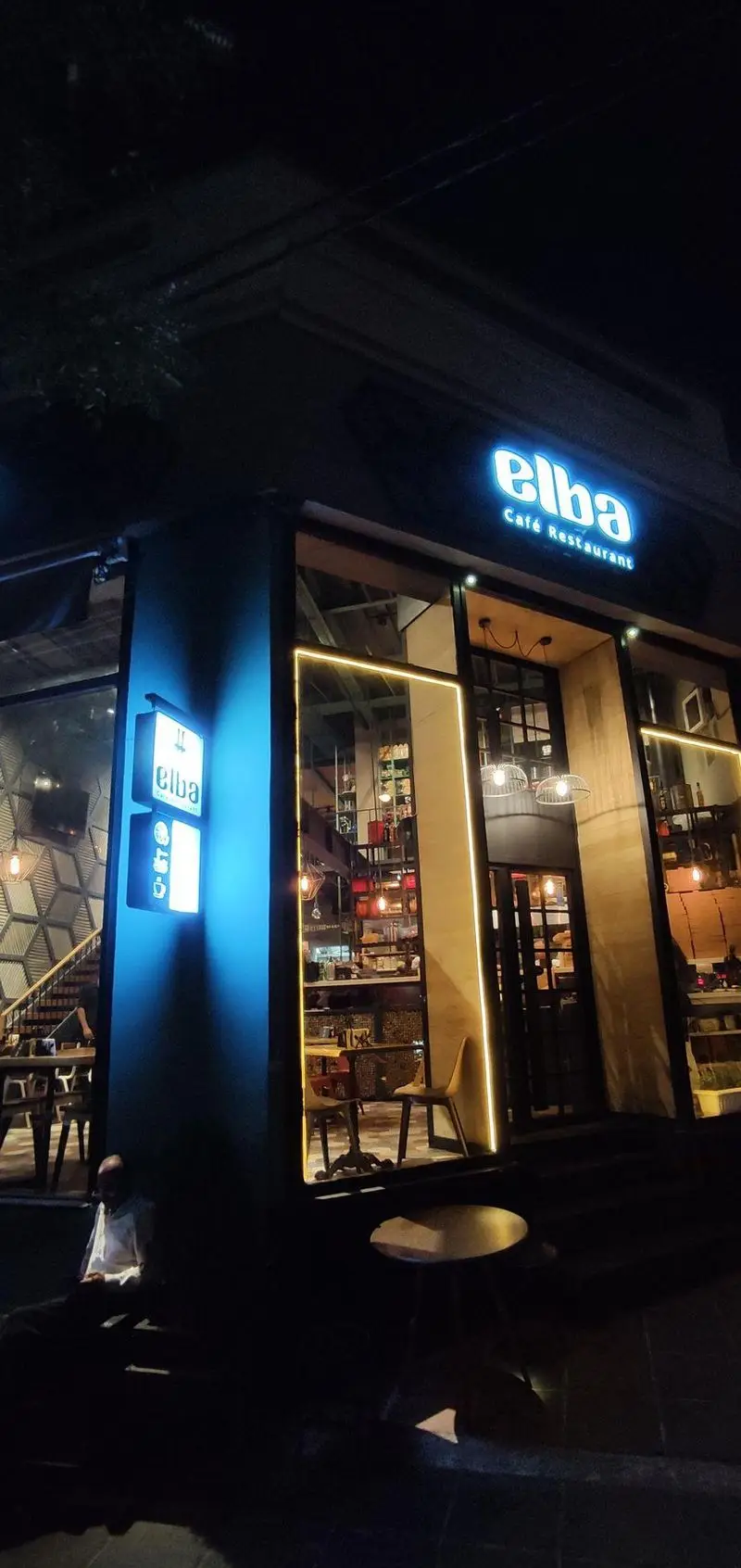 تصویر شبانه از نمای بیرونی کافه رستوران البا با تابلوی نورانی "elba Cafe Restaurant" و ورودی شیشه ای با دکوراسیون داخلی مدرن.