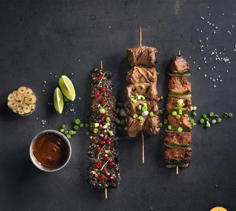 تصویری جذاب از سه سیخ کباب متنوع و لذیذ رستوران های‌نون: کباب گوشت، کوبیده و مرغ، آماده برای سفارش آنلاین.