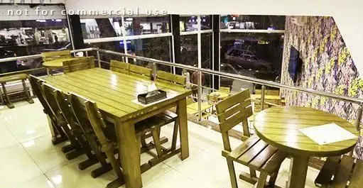 فضای داخلی دنج و مدرن پیتزا هات با میز و صندلی‌های چوبی، ایده‌آل برای لذت بردن از پیتزا و منظره شب شهر.