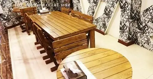 دکوراسیون داخلی شیک و مدرن پیتزا هات با میز و نیمکت‌های چوبی، دیوارپوش‌های طرح گرافیتی سیاه و سفید؛ محیطی دلپذیر.