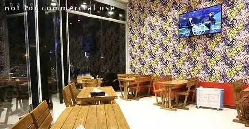 فضای داخلی مدرن و دنج پیتزا هات، شامل میز و صندلی‌های چوبی، دیوار با طرح‌های خاص و تلویزیون. محیطی عالی برای لذت بردن از غذا.