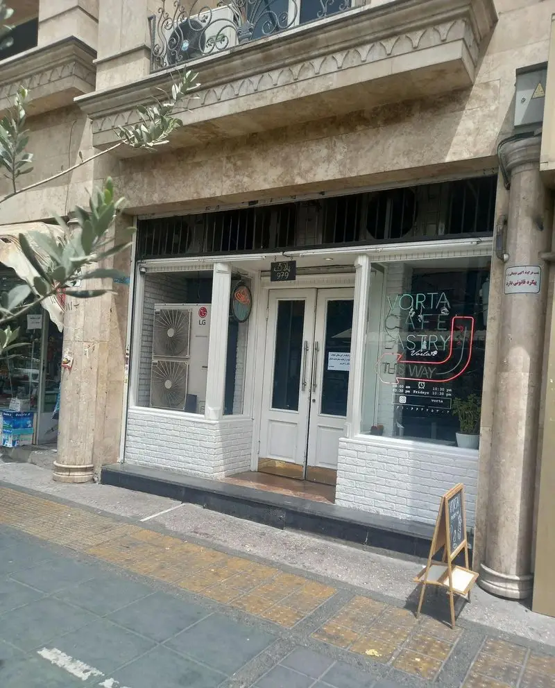 ورودی جذاب کافه قنادی کیک ورتا، مکانی دلنشین برای علاقه‌مندان به کیک، شیرینی، قهوه با تابلو نئون VORTA CAFE PASTRY.