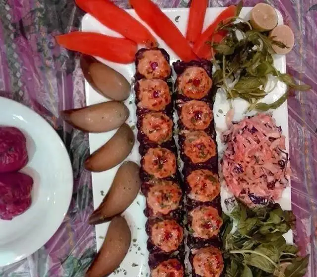 سرو غذای شیک و خوشمزه کافی شاپ رویال شامل کباب کوفته با چیدمان زیبا، سبزیجات تازه، سالاد و فلفل کبابی روی میز شام.