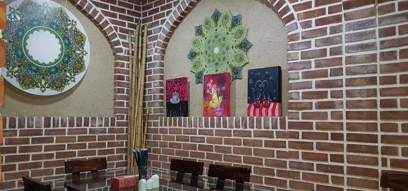 دکوراسیون داخلی رستوران و کافه اسپرلوس با دیوارهای آجری، طاق‌های زیبا، آثار هنری مدرن و طرح‌های سنتی. فضایی دنج و آرام برای مشتریان.