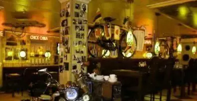 فضای داخلی و دکوراسیون خاص رستوران ایتالیایی رز ایتالیایی با موتورسیکلت‌ها، ستون پر از عکس و نورپردازی گرم، محیطی دلنشین برای مشتریان.