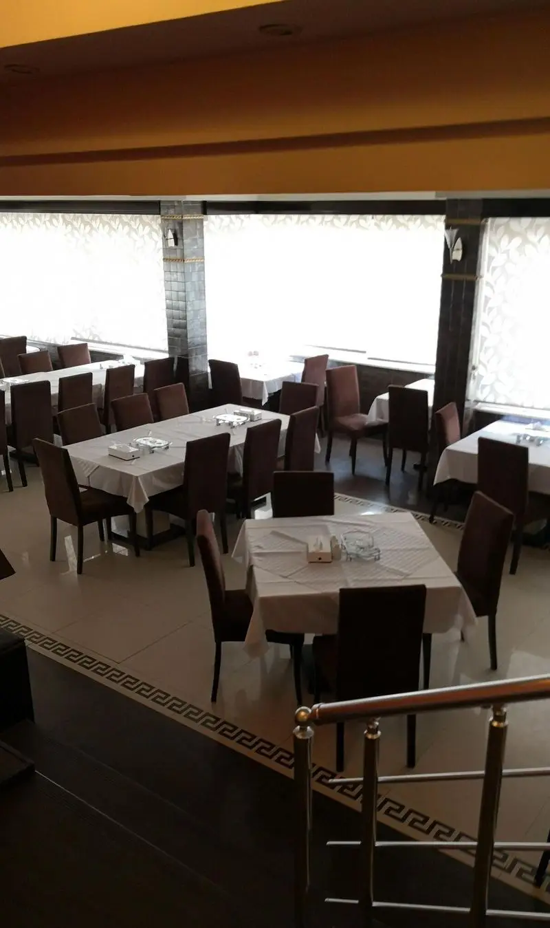 نمایی از سالن غذاخوری چلو کباب نایب، با میزهای مرتب و رومیزی‌های سفید، صندلی‌های قهوه‌ای و پنجره‌های نورگیر. محیطی دلنشین و دکوراسیون شیک.