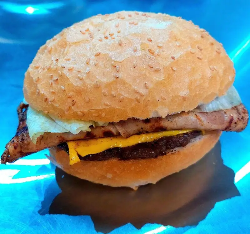 یک همبرگر ویژه و خوشمزه از فست فود آرام ناز با نان کنجدی، گوشت برگر، سینه مرغ گریل، پنیر و کاهو تازه، انتخابی عالی برای غذای آماده.