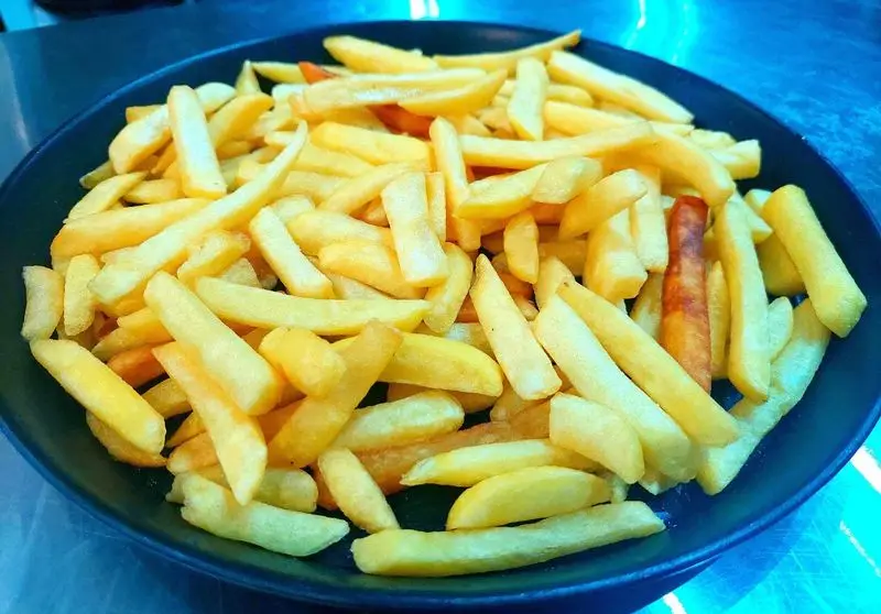 یک بشقاب پر از سیب زمینی سرخ کرده داغ و خوشمزه از فست فود آرام ناز، بهترین انتخاب برای یک وعده غذایی سریع و لذیذ.