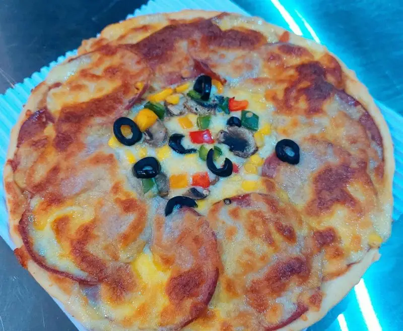 پیتزا مخلوط خوشمزه فست فود آرام ناز با پنیر طلایی، پپرونی، قارچ، زیتون، فلفل دلمه‌ای رنگی و ذرت تازه. یک وعده غذایی لذیذ و پرطرفدار.