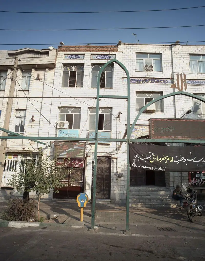 نمای بیرونی رستوران فرخ سرو در محله‌ای پر رفت و آمد. ساختمان با پنجره‌های قوسی و تایل‌های سفید، بنر و ورودی قهوه‌ای.