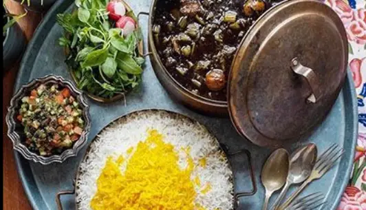 سفره غذای سنتی ایرانی از رستوران کترینگ طعام یاس: خورشت قورمه سبزی، پلو زعفرانی، سالاد شیرازی و سبزی خوردن تازه