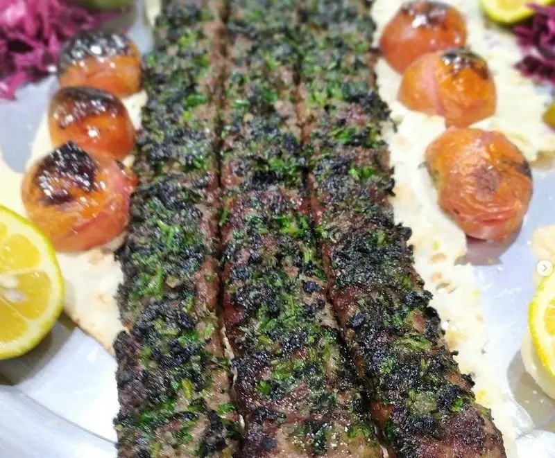 سینی زیبای کباب مخصوص سبزی‌دار باغ رستوران شادی، با گوجه کبابی آبدار، نان داغ و لیمو ترش تازه. غذای اصیل ایرانی.