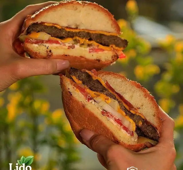 عکس ساندویچ همبرگر گوشت تازه و پنیر چدار لذیذ رستوران لیدو، با بیکن ترد، پیاز و گوجه فرنگی آبدار.