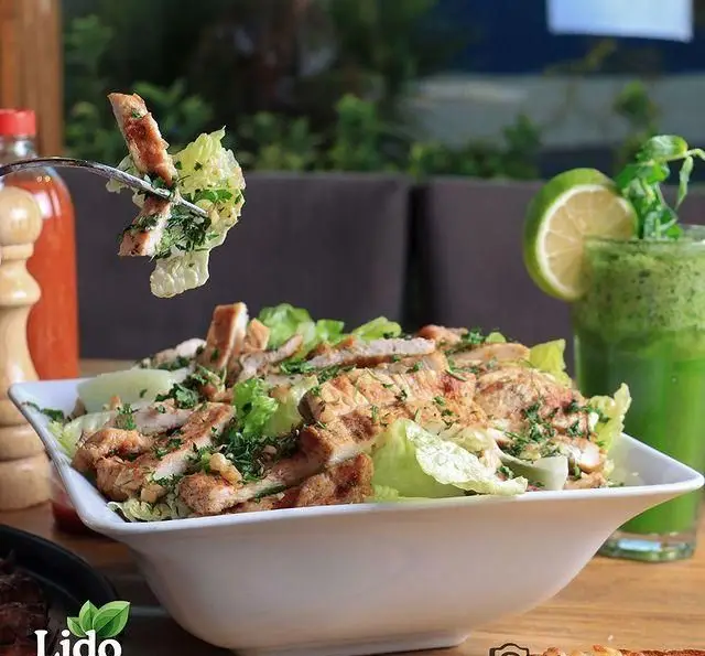 سالاد سزار مرغ گریل شده و تازه رستوران ایتالیایی لیدو با سبزیجات معطر و نوشیدنی سالم، انتخابی عالی برای یک وعده لذیذ.