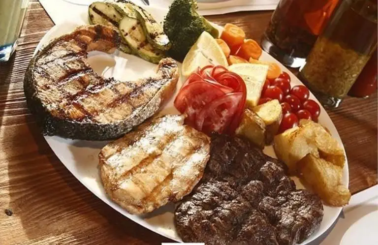 یک بشقاب بزرگ و لذیذ از رستوران ایتالیایی لیدو شامل ماهی سالمون، استیک گوشت و مرغ گریل شده با سبزیجات تازه و کبابی.