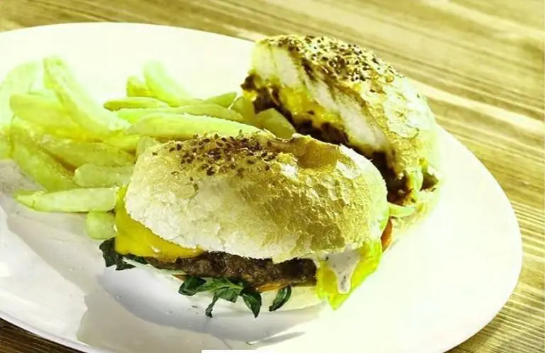 برگرهای لذیذ رستوران ایتالیایی لیدو با نان سسمی، گوشت تازه، پنیر ذوب شده، کاهو و سیب زمینی سرخ کرده کنار بشقاب.