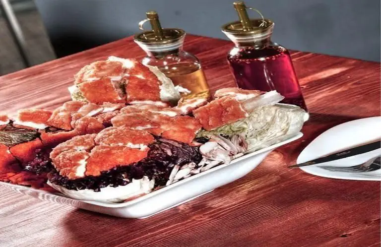 نمایی اشتهاآور از شنیتسل مرغ یا مرغ سوخاری به همراه سالاد رنگارنگ کلم در سینی بزرگ رستوران ایتالیایی لیدو.