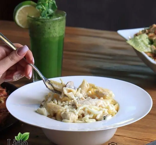 پاستا مرغ و قارچ کرمی خوشمزه در رستوران ایتالیایی لیدو، همراه با نوشیدنی سبز. تجربه‌ای دلنشین و به یادماندنی از غذای ایتالیایی.