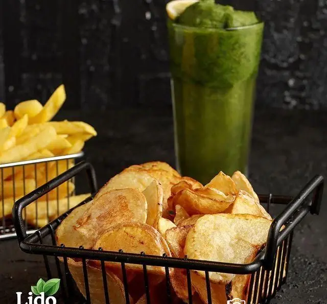 لذت چیپس سیب‌زمینی خانگی، سیب‌زمینی سرخ‌کرده طلایی و اسموتی سبز تازه در رستوران ایتالیایی لیدو، تجربه‌ای دلنشین.