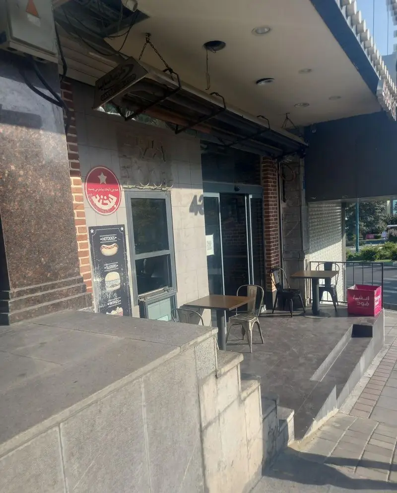 نمای فست فود گامبی ساندویچ: رستورانی با فضای باز، میز و صندلی، ایده‌آل برای ساندویچ، هات داگ، اسلایدر و سفارش بیرون بر.